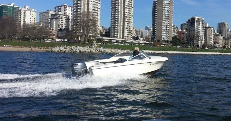 Speedboat cruising near Vancouver skyline on Burrard Inlet