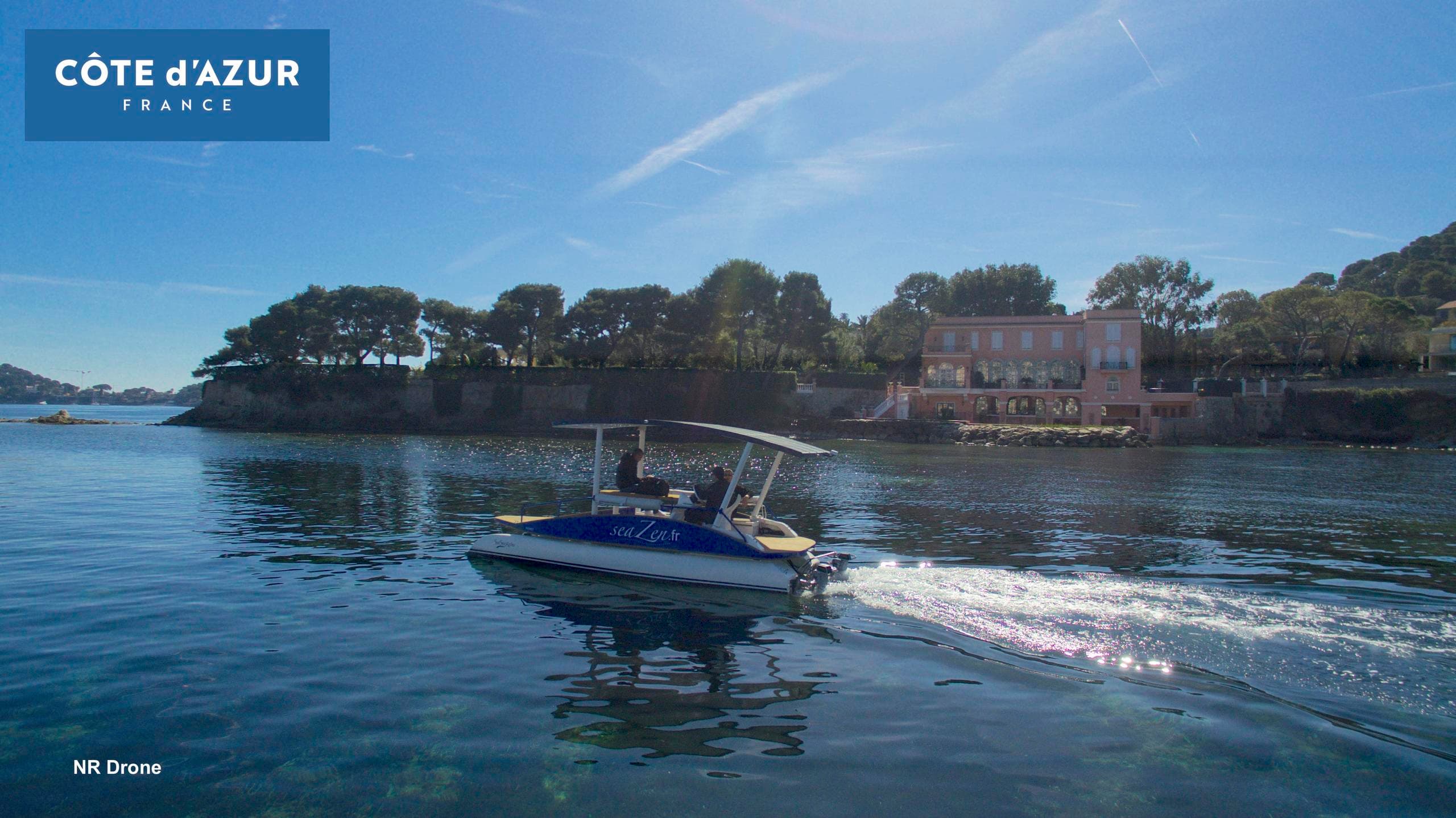 Motorboat cruising past island on Côte d'Azur coastline