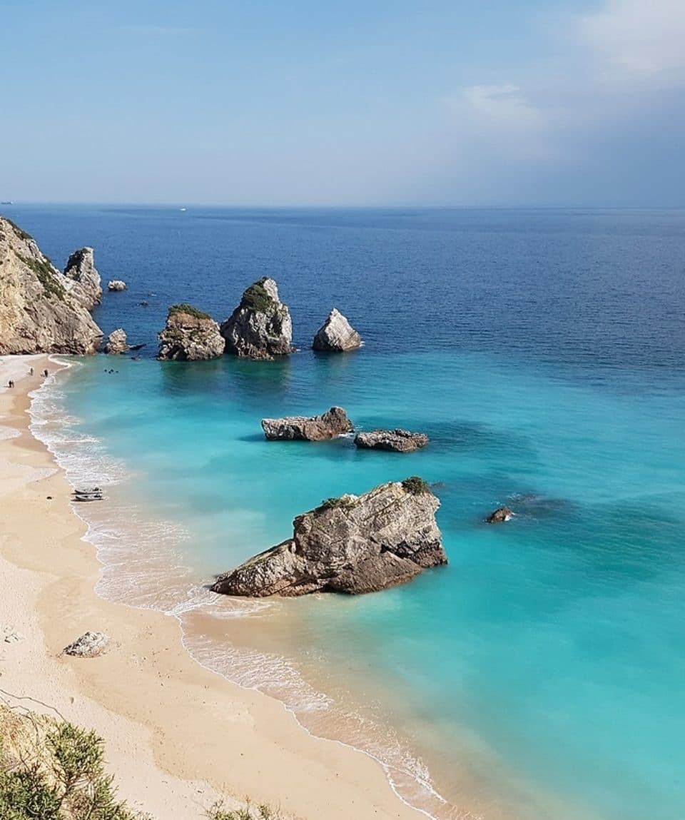 Sandy cove with turquoise water and sea stacks on sunny coast