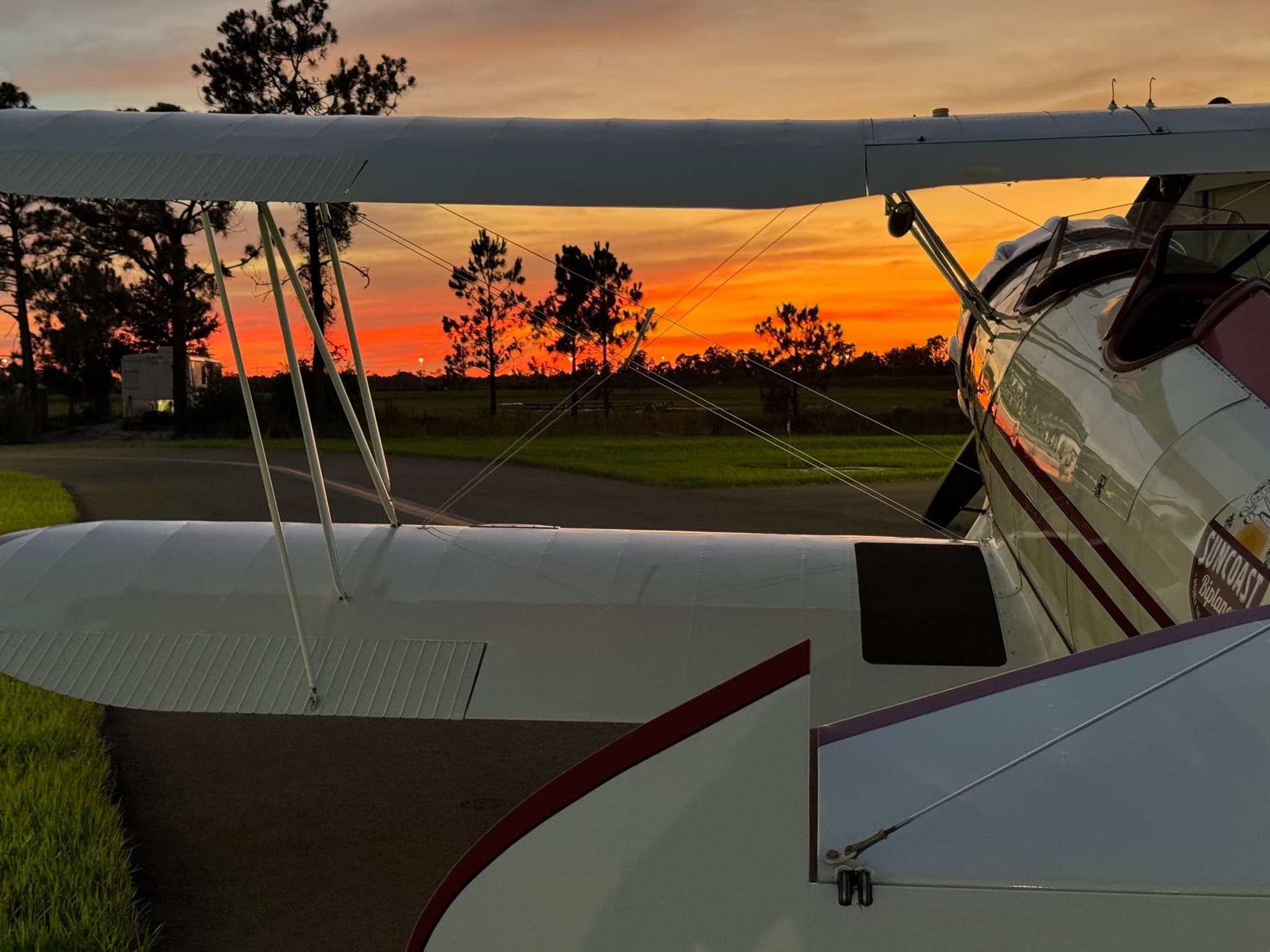 Vintage biplane on runway at sunset offering scenic flights