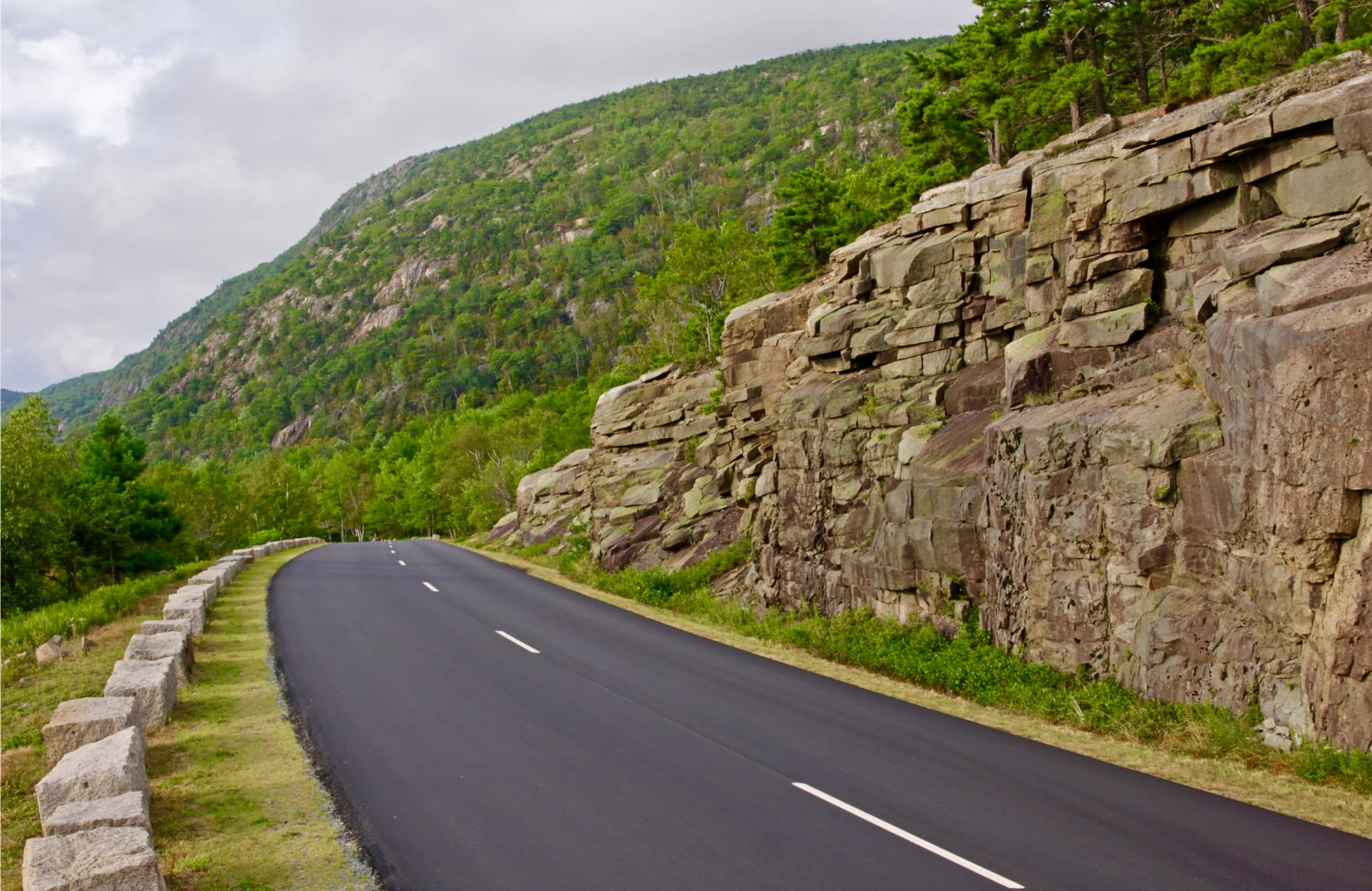 Mountain road carved beside rocky cliffs for scenic driving