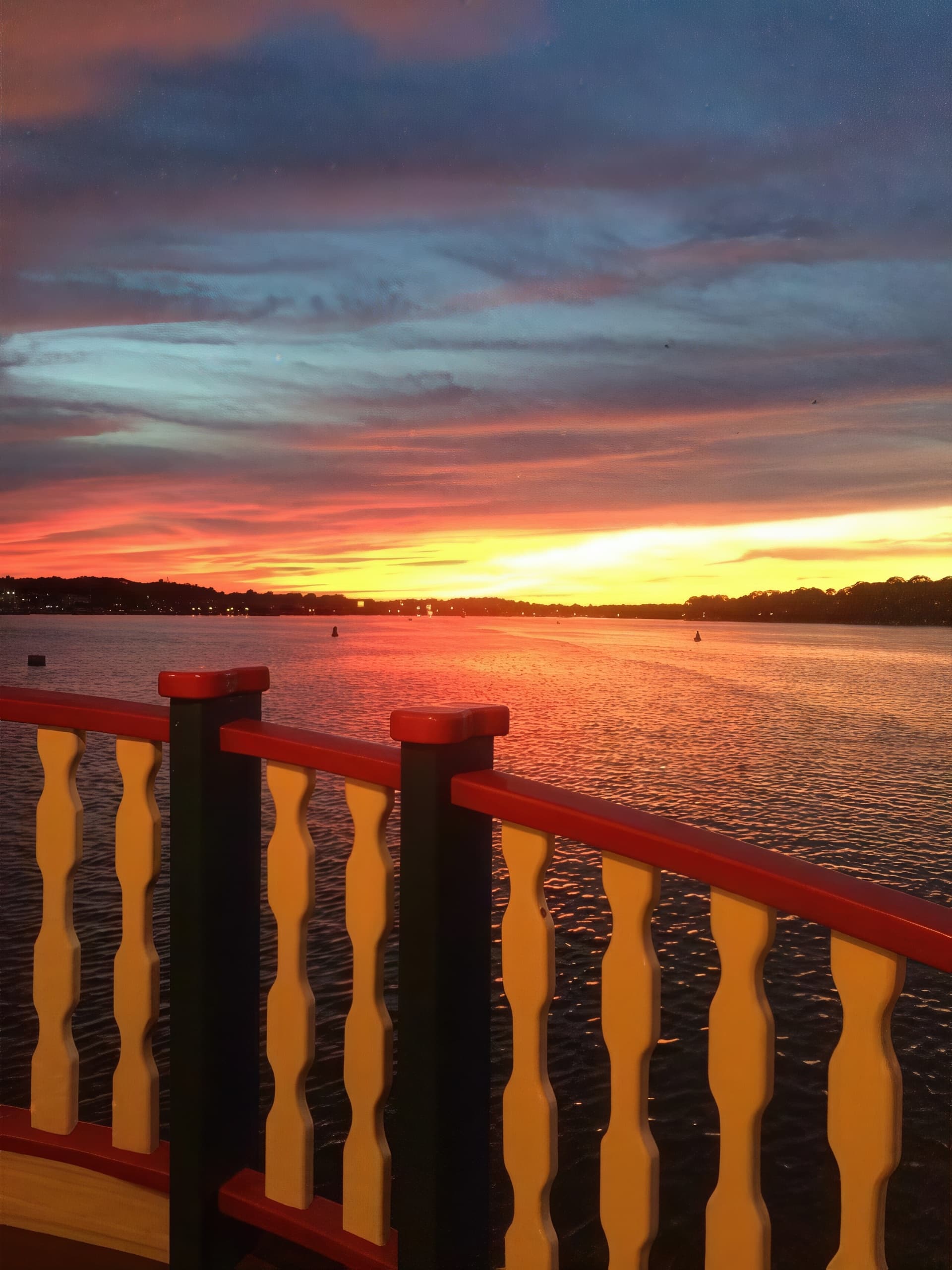 Sunset over river from boat railing on scenic evening cruise