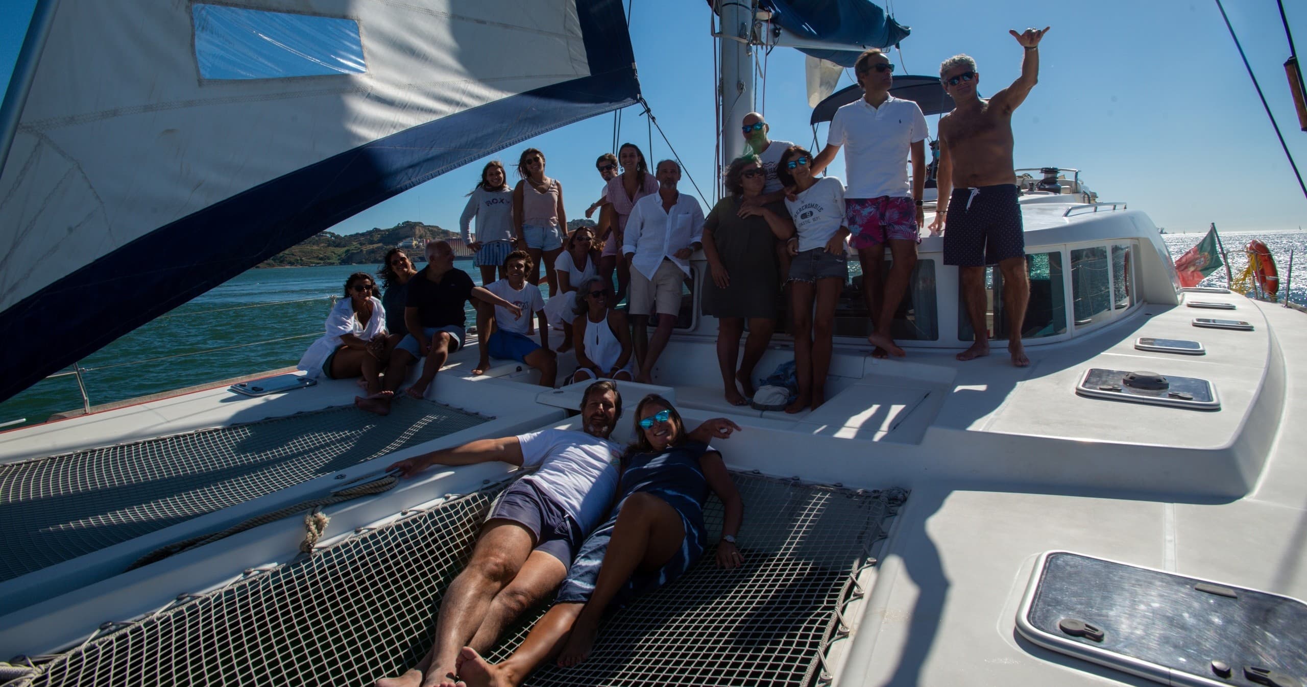 Group lounging on catamaran deck during sunny ocean cruise