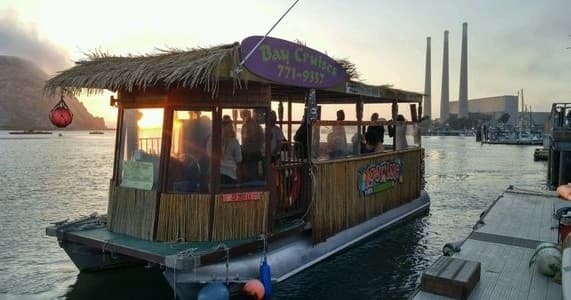 Tiki cruise boat docked at Morro Bay harbor during sunset