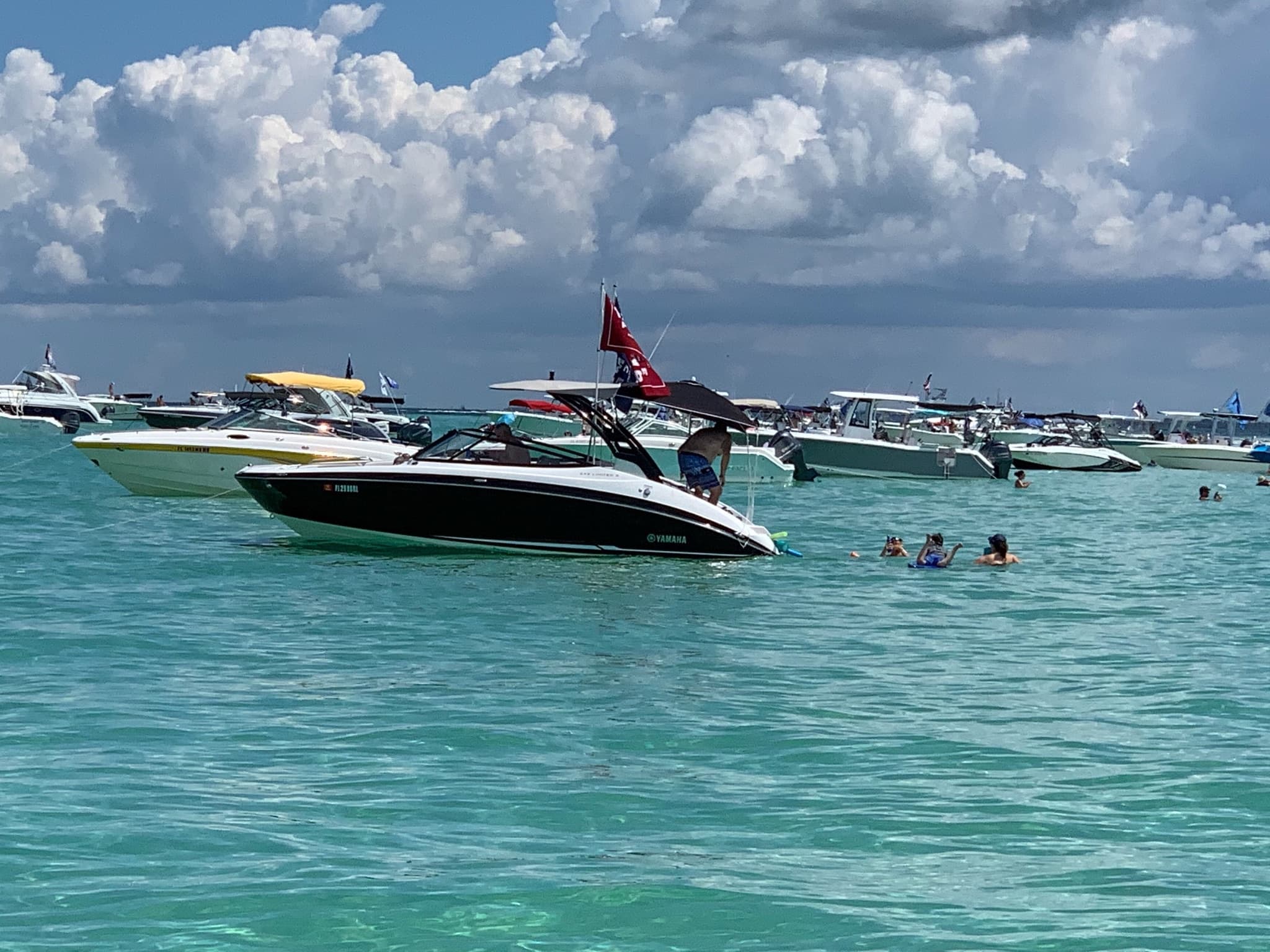 Motorboats anchored in turquoise Sarasota waters, beach day