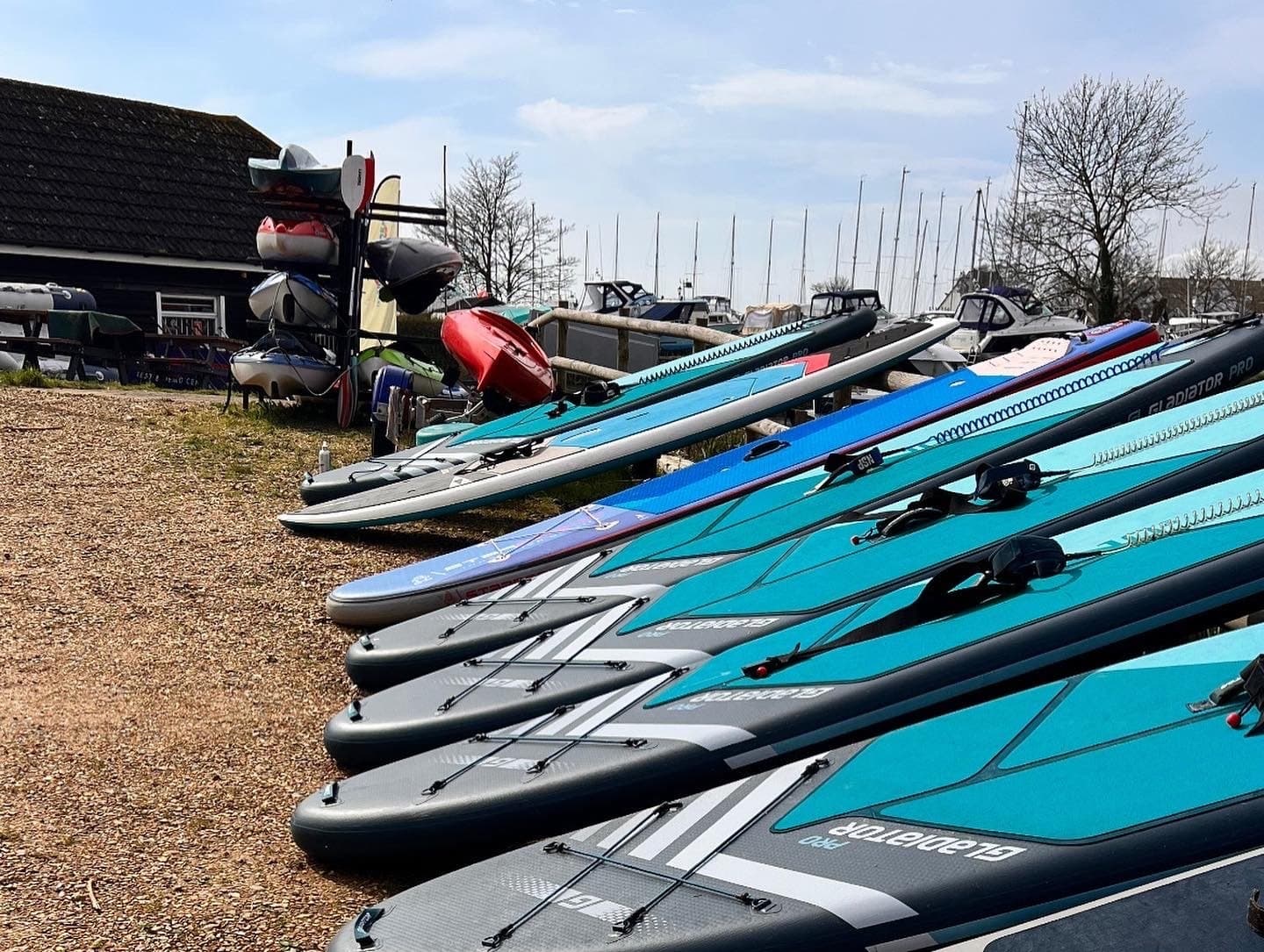 Stacked paddleboards on sandy beach ready for lessons