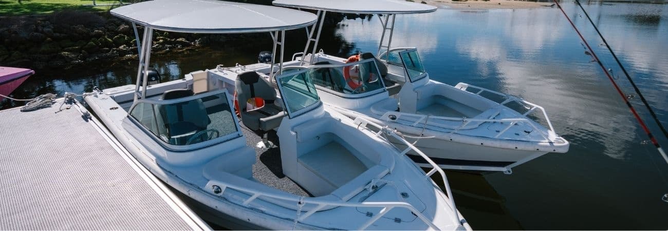 Twin speedboats moored at a marina on calm coastal waters