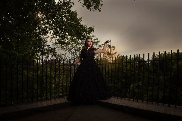 Woman in Victorian gown overlooking Providence park at dusk