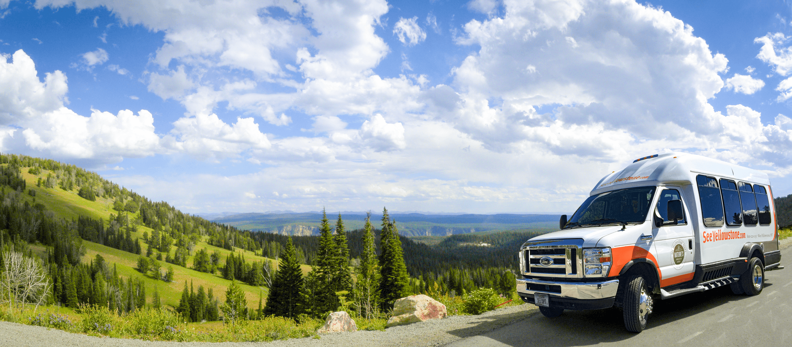 Scenic shuttle van on Yellowstone road with rolling hills vista