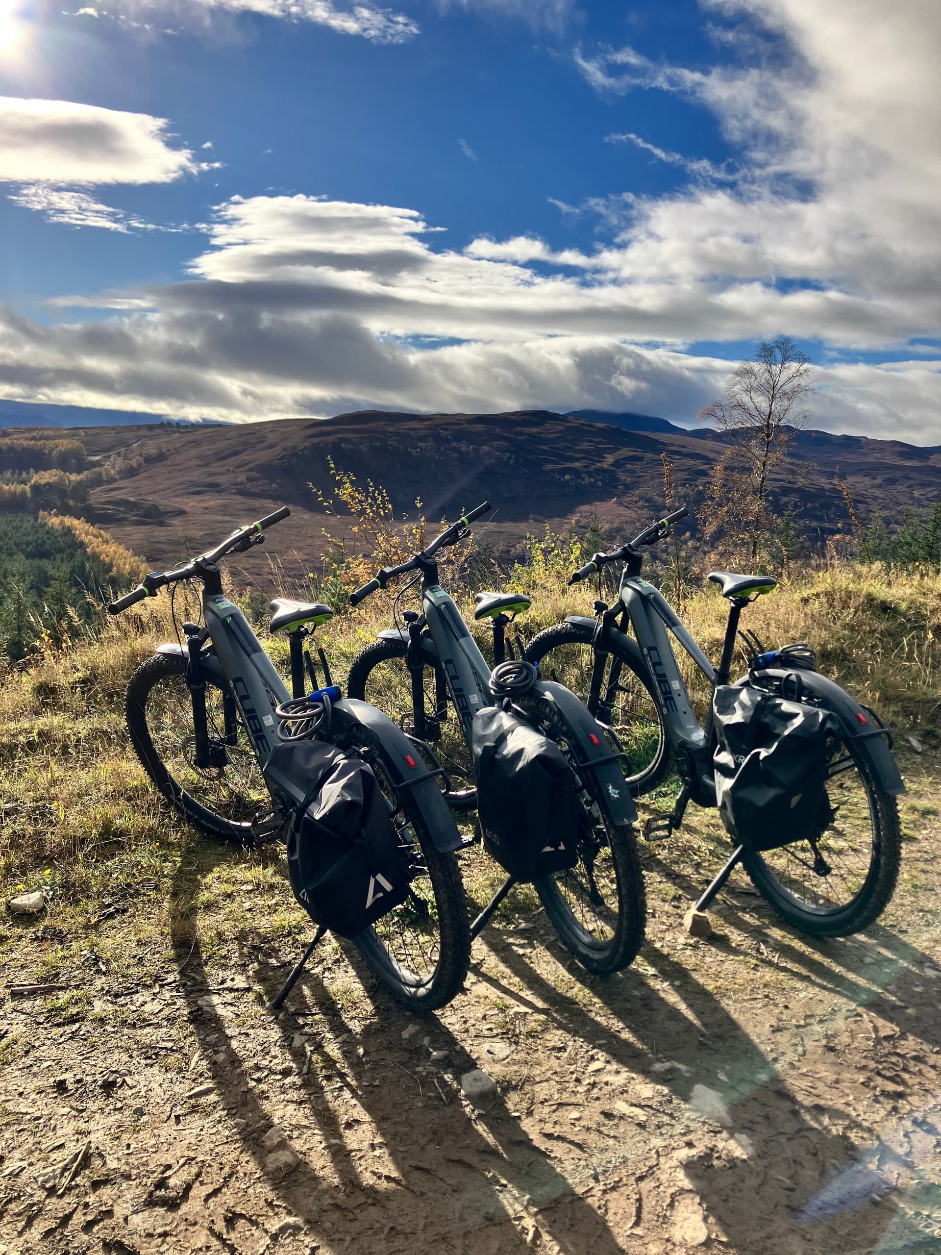Electric bikes parked on hillside trail with panoramic views