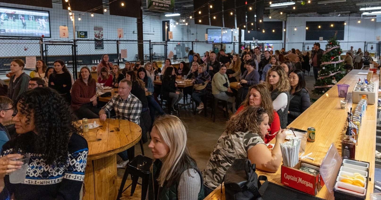 Crowd enjoying indoor brewery-style bowling social event