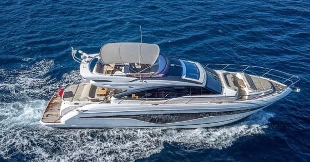 Aerial luxury yacht navigating deep blue coastal waters during daylight