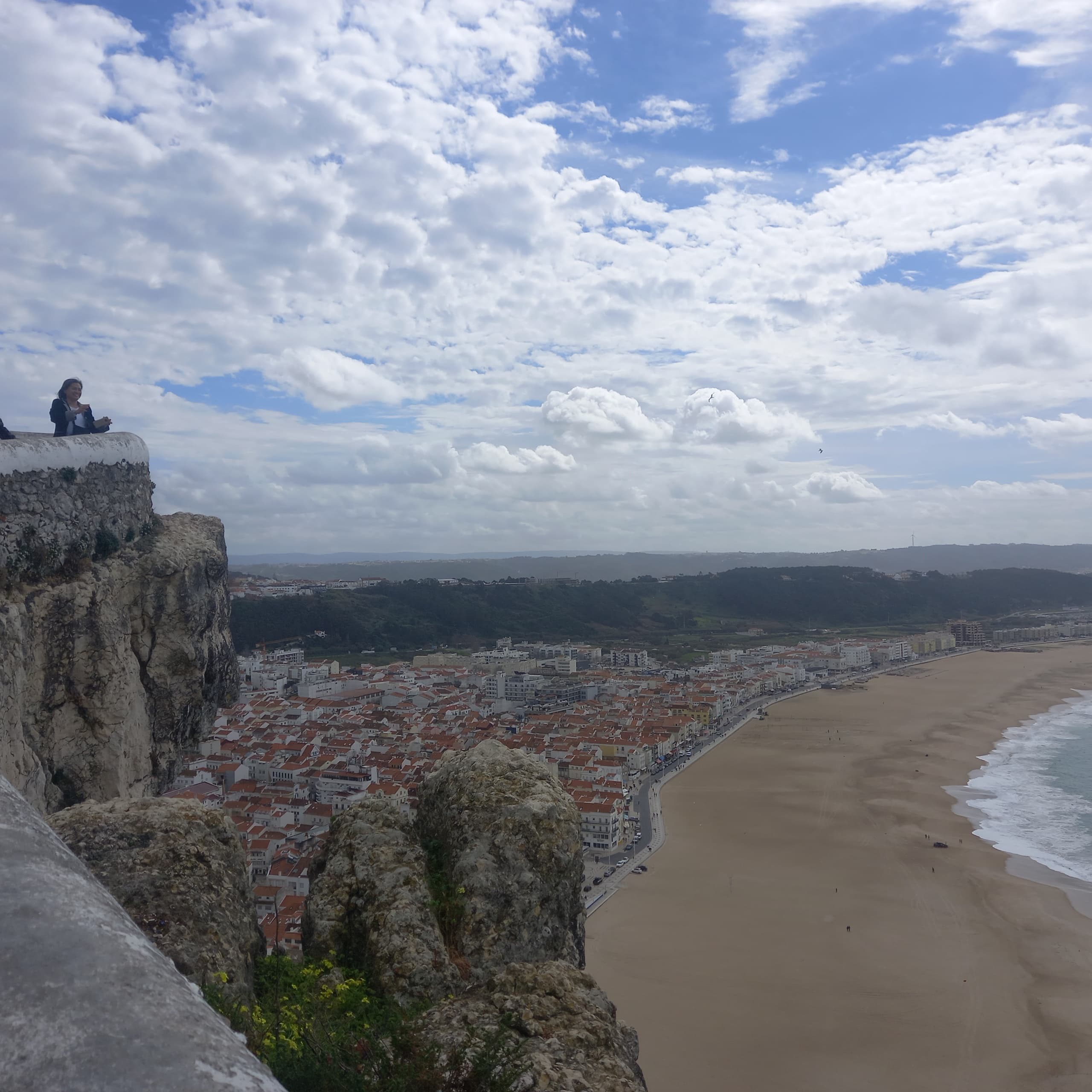 Hiking cliffside trail above sandy beach and Atlantic shoreline
