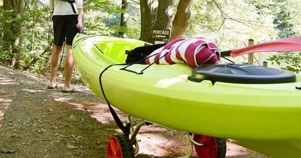 Kayak on wheeled cart on wooded trail near Bethany Beach shore