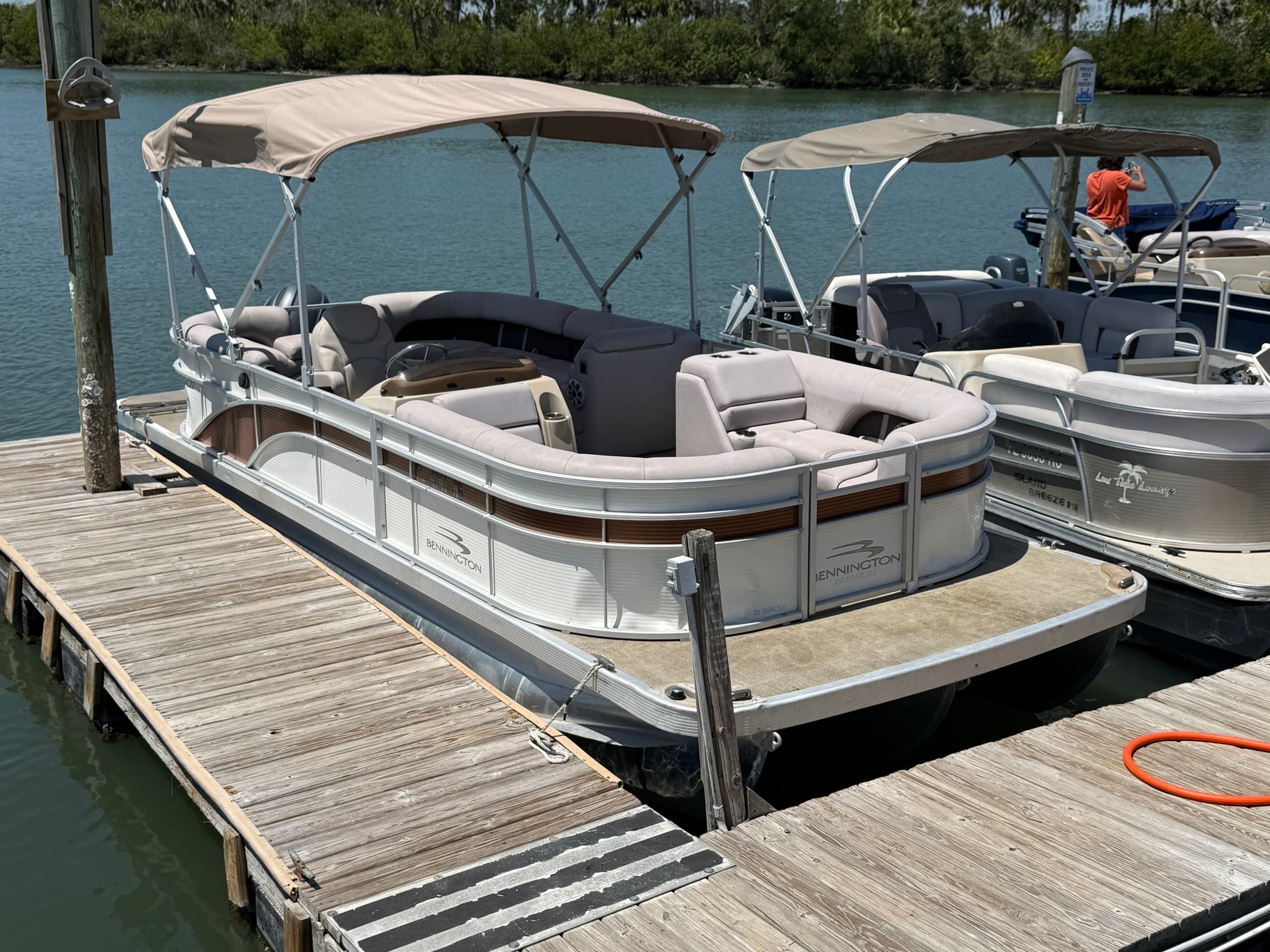 Pontoon boat with passengers enjoying sunset cruise on bay