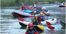 Group of kayakers paddling on calm river during guided trip