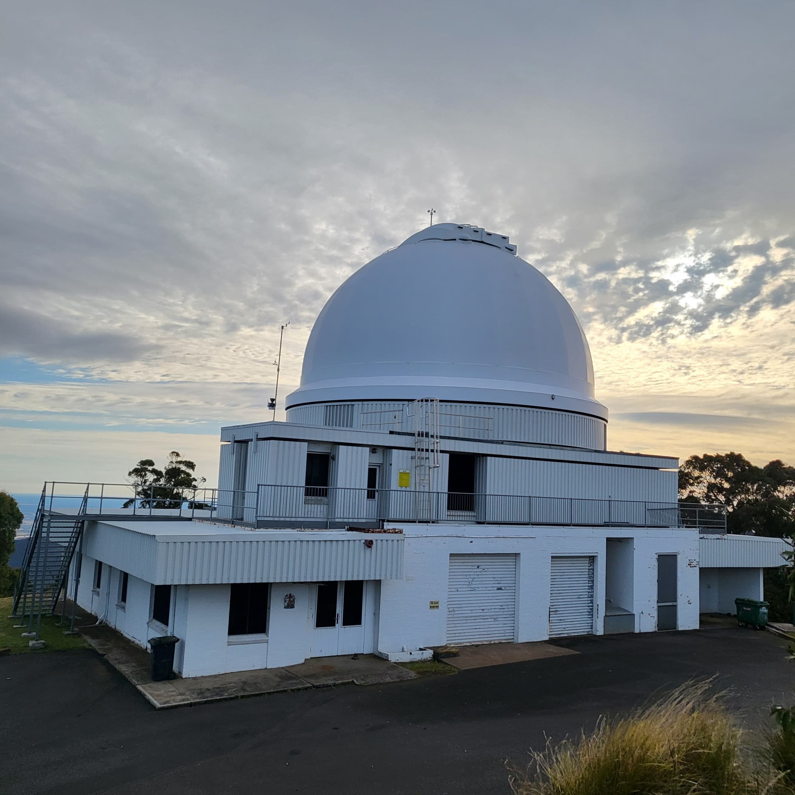 Large research observatory building with dome under cloudy sky