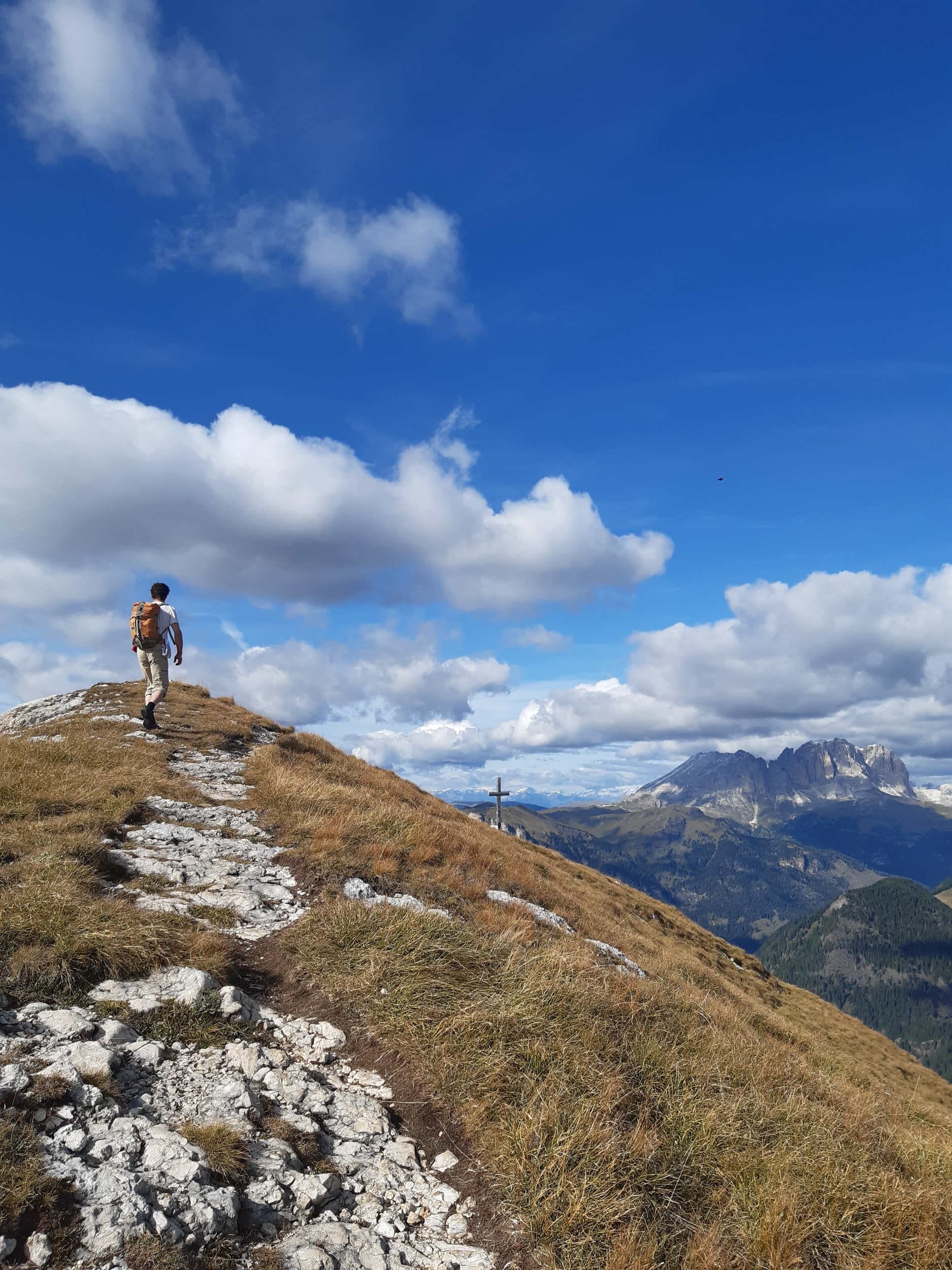 Solo hiker trekking a rocky alpine ridge with distant peaks