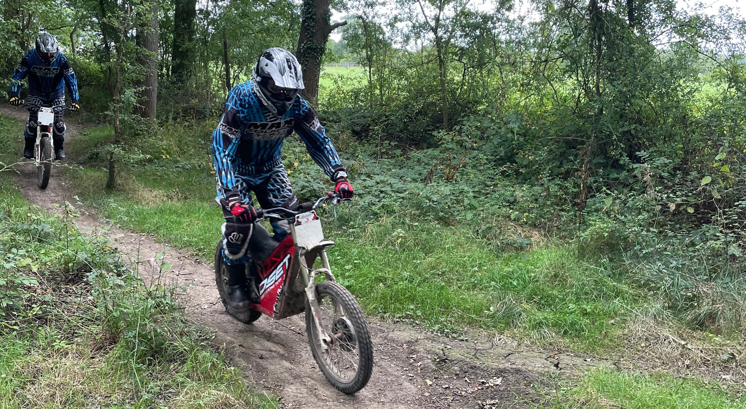 Off-road trials rider on muddy forest trail during action