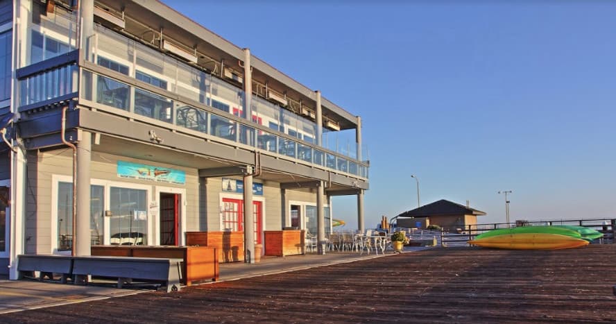 Harborfront building and pier at sunrise, waterfront adventure base