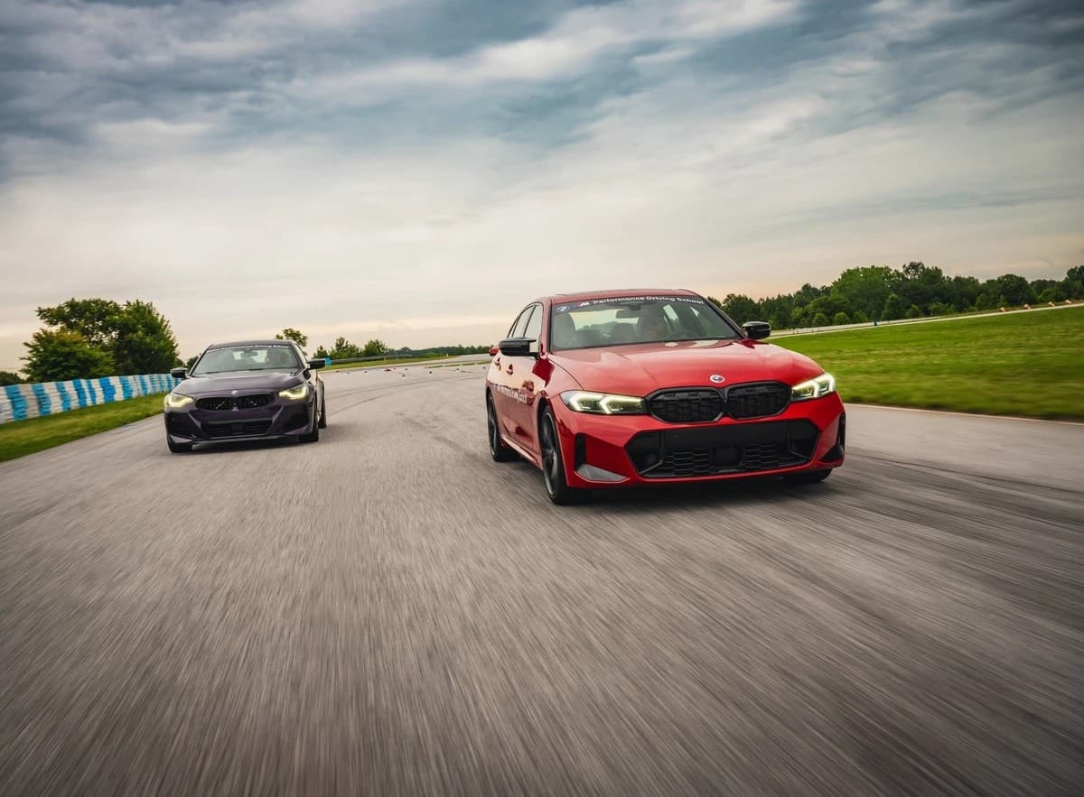 Red BMW leading on open racetrack, dynamic performance driving