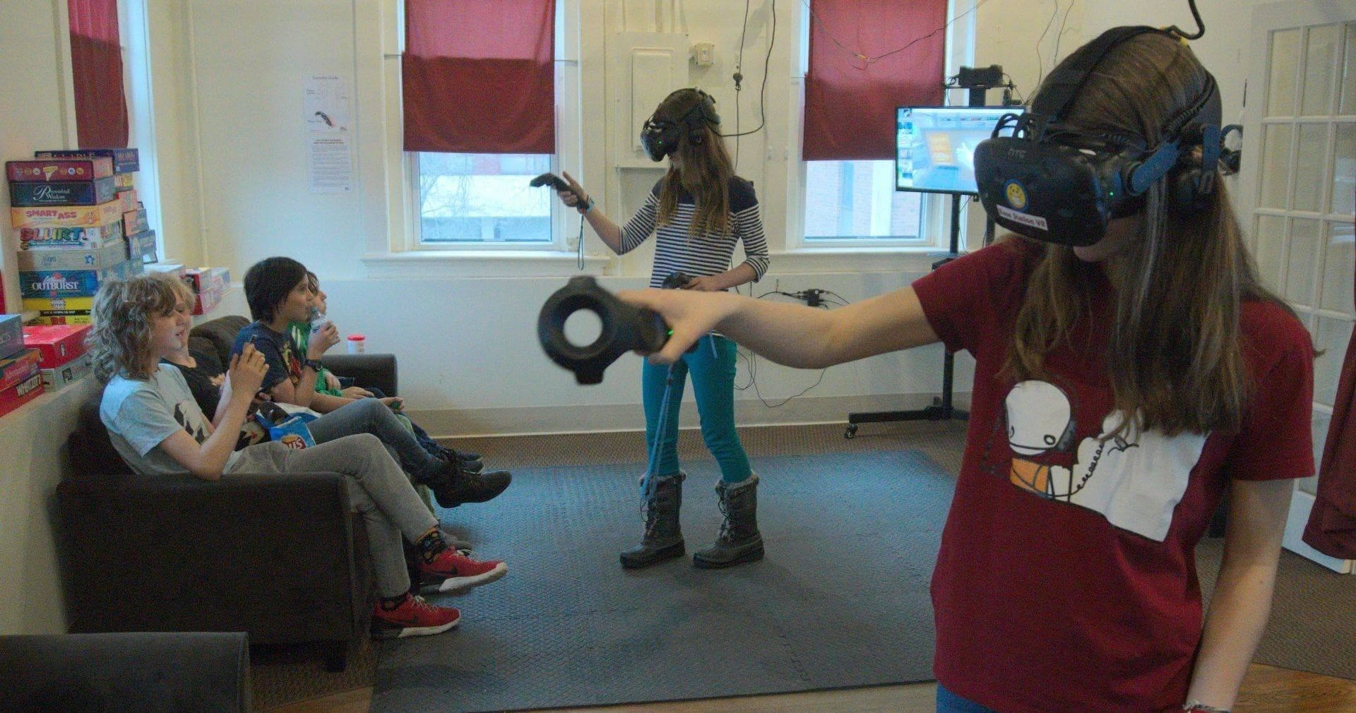 Teens using VR controllers in indoor virtual reality lounge