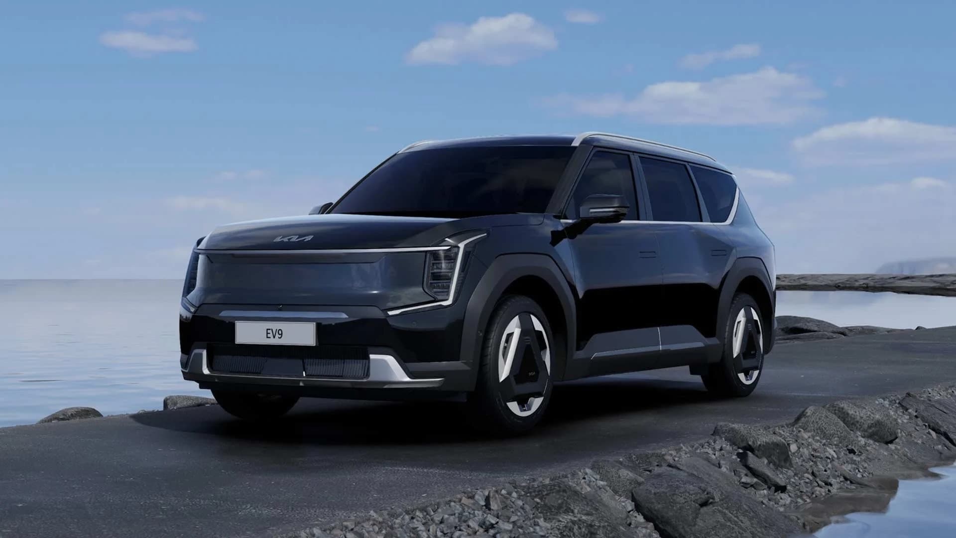Electric SUV parked on rocky shoreline with ocean view