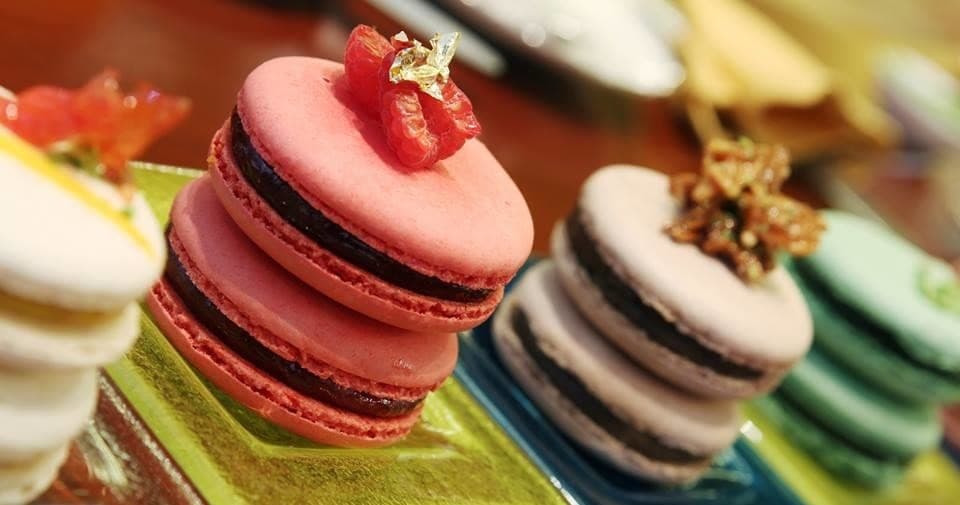 Colorful French macarons arranged on market counter, closeup