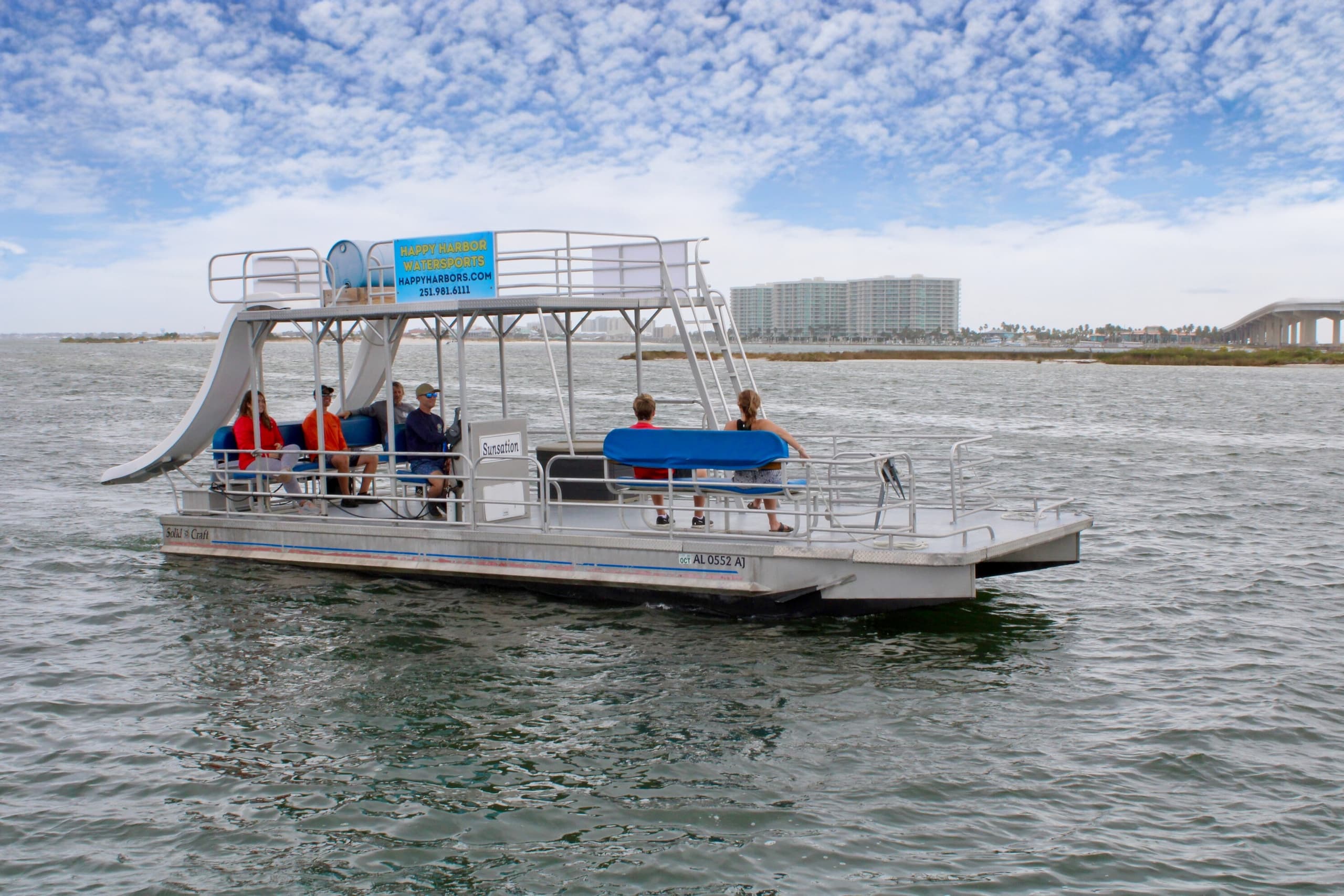 Open pontoon boat cruising near beachfront resorts at sea