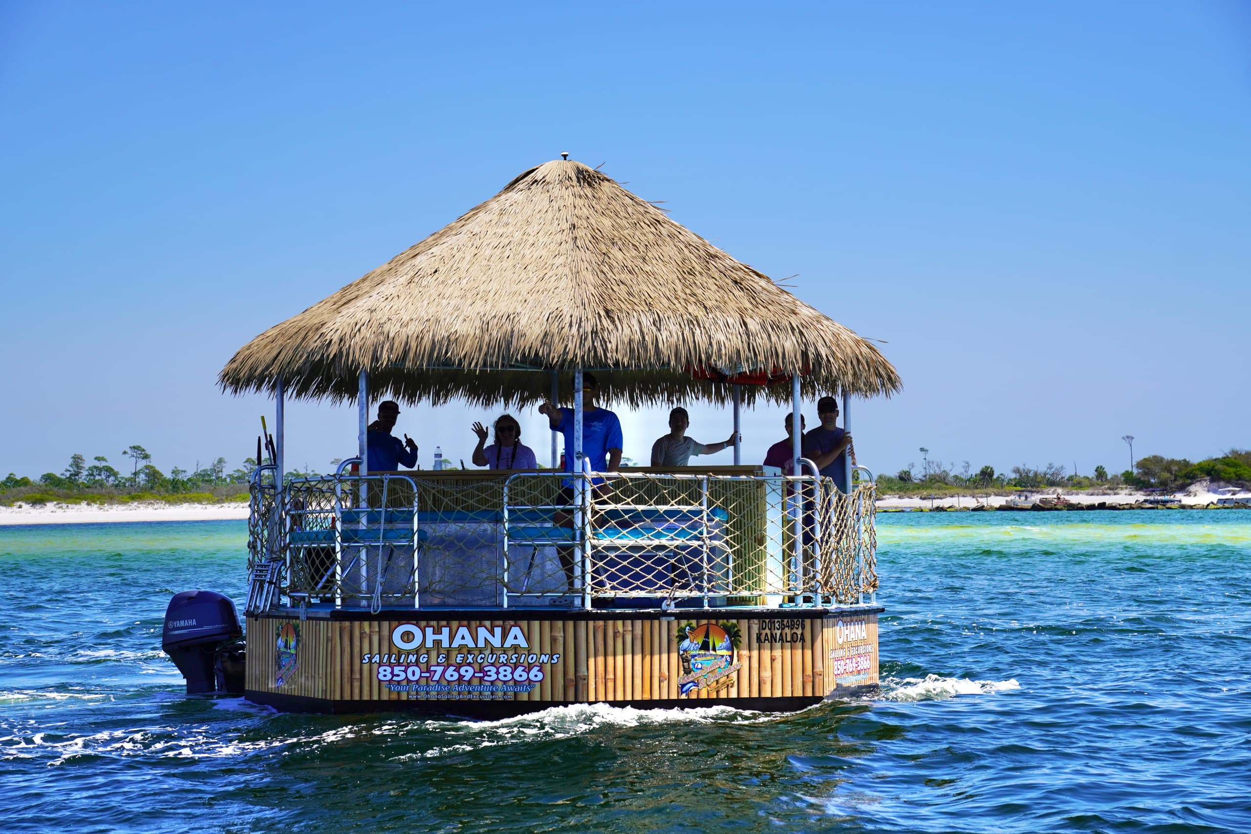 Thatched tiki pontoon (Ohana) cruising barrier island waters