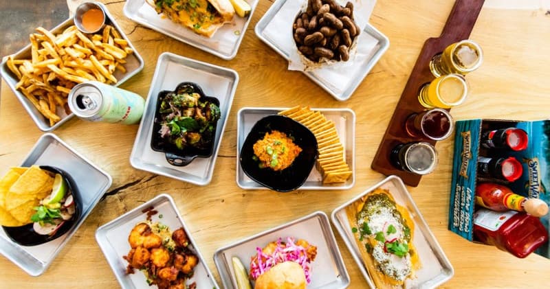 Taproom spread of appetizers and fries on wooden table