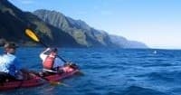 Tandem kayakers paddling on Pacific waters near Nā Pali Coast, Kauai