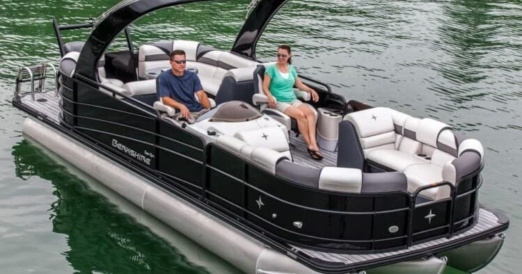 Pontoon boat with passengers on green bay, leisure cruising