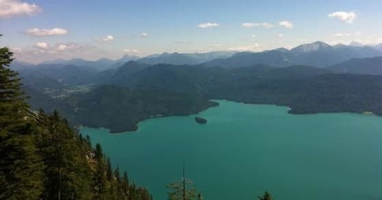 Turquoise alpine lake with forested shoreline in Bavarian mountain valley