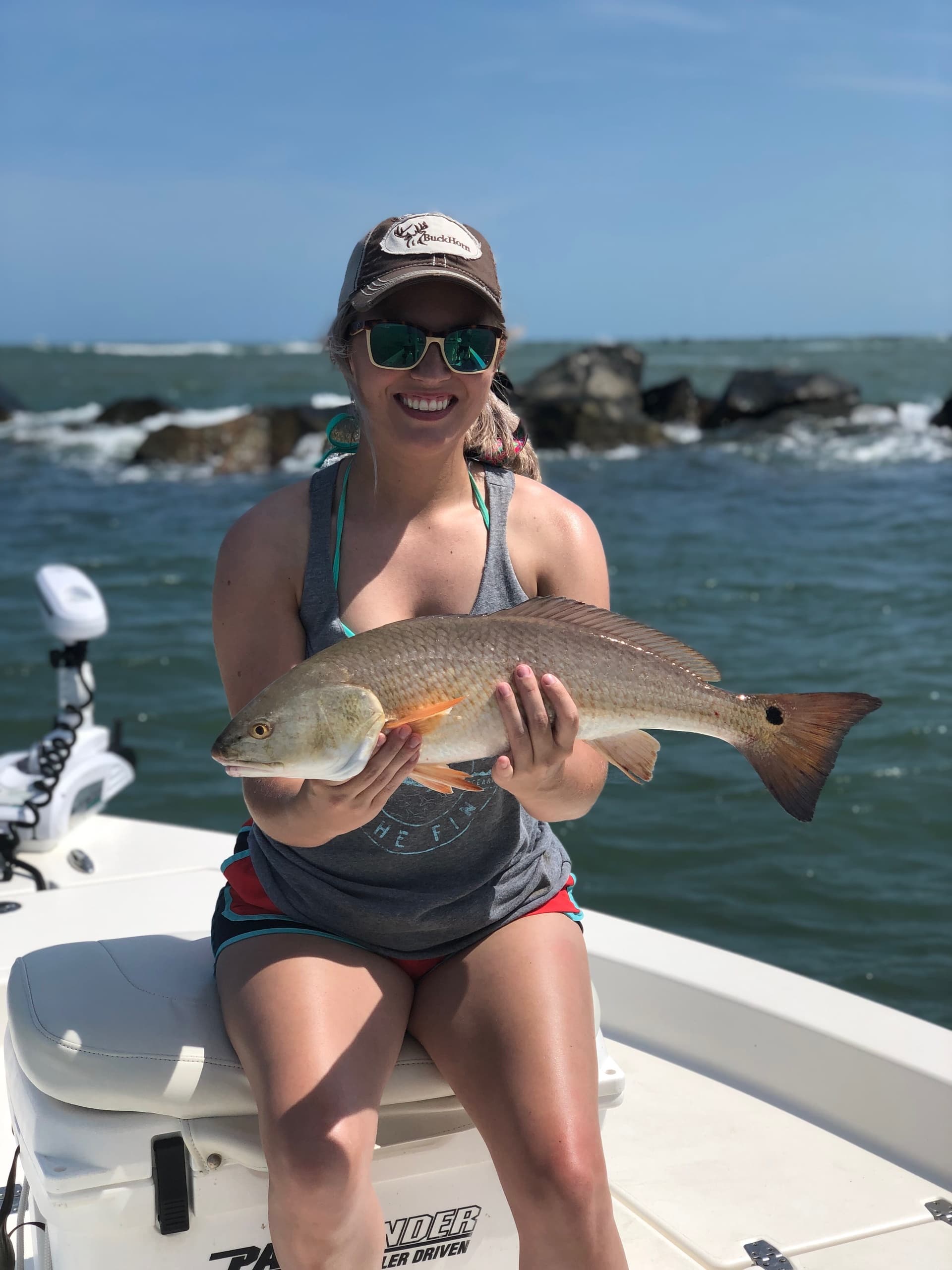 Female angler holding redfish on a shallow-water charter