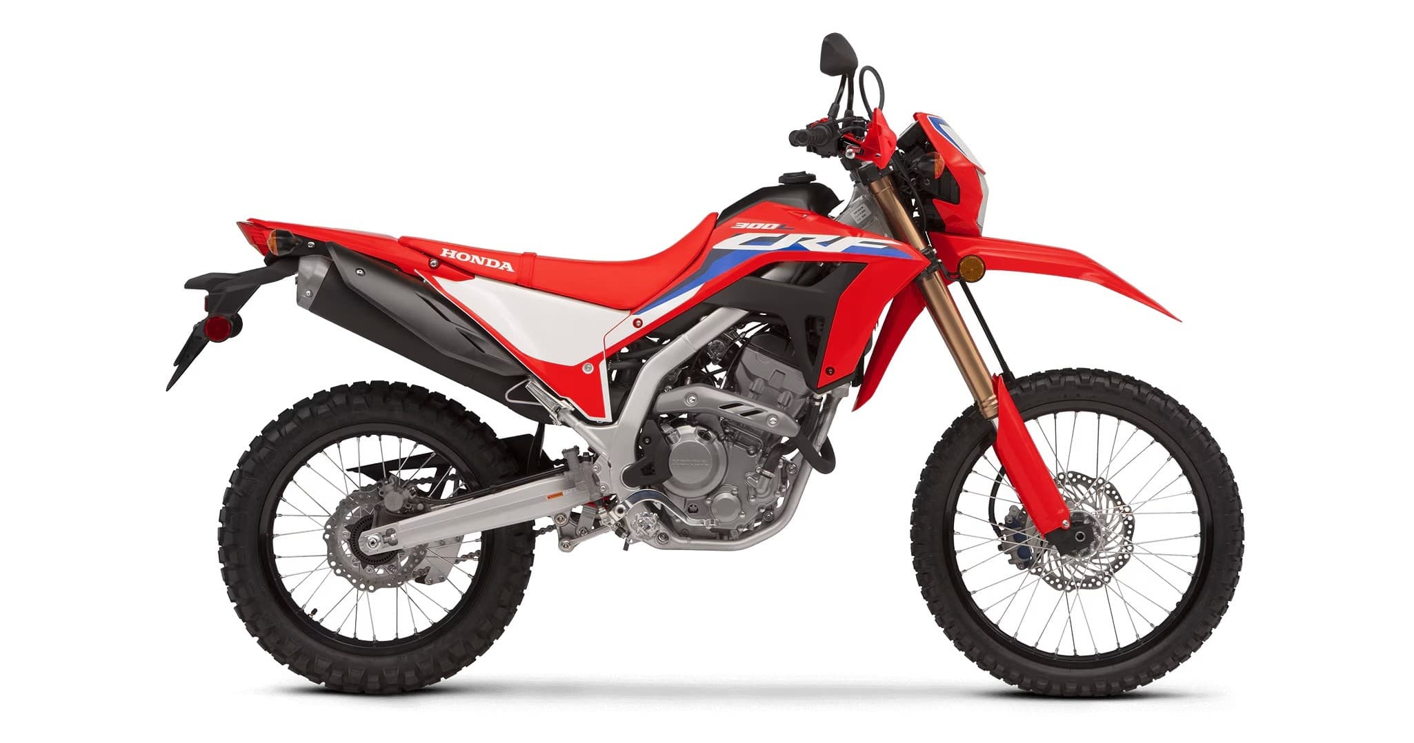 Red dual-sport dirt motorcycle side profile studio image on white