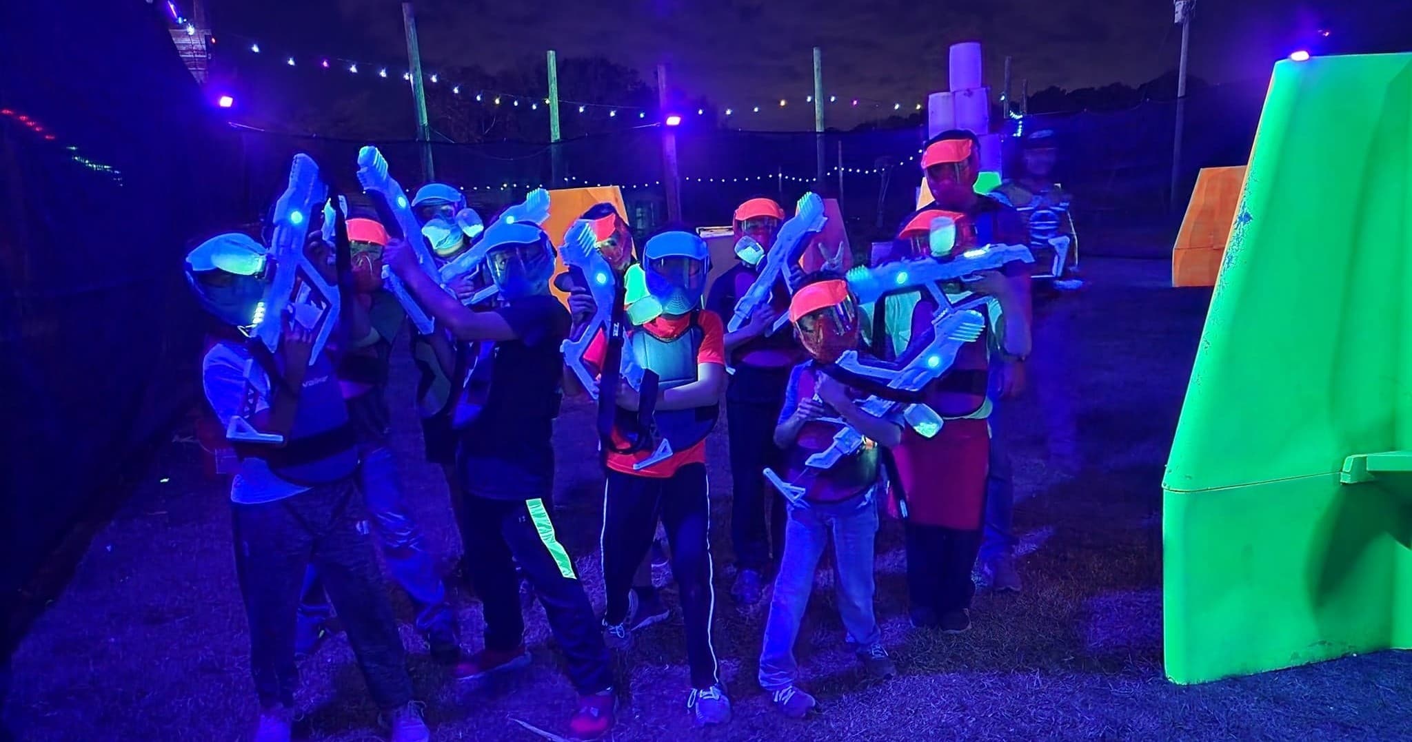 Group wearing vests and goggles for blacklight laser tag outdoors