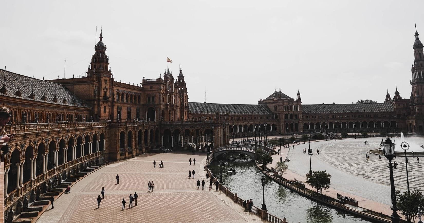 Panoramic Plaza de España in Seville with visitors strolling