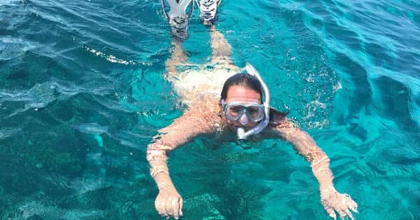 Snorkeler floating face-down in crystal clear tropical sea