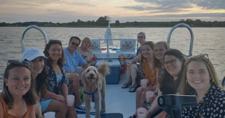 Group boating on harbor pontoon at sunset, scenic cruise