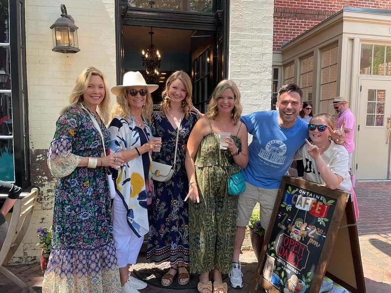 Smiling food tour participants posing outside restaurant entrance DC