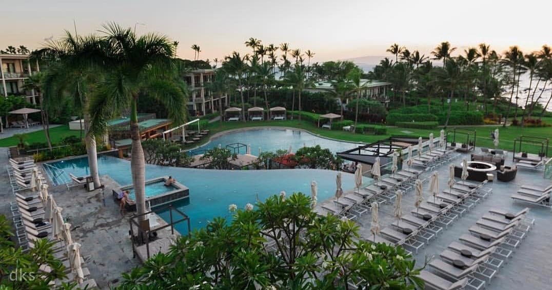 Resort pool deck with lounge chairs overlooking landscaped grounds