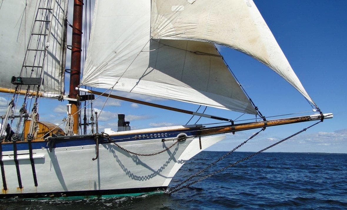 Classic tallship bow cutting through blue ocean waters