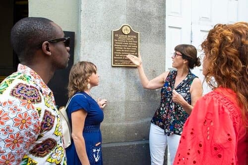 Tour guide pointing at historical plaque during New Orleans walking tour