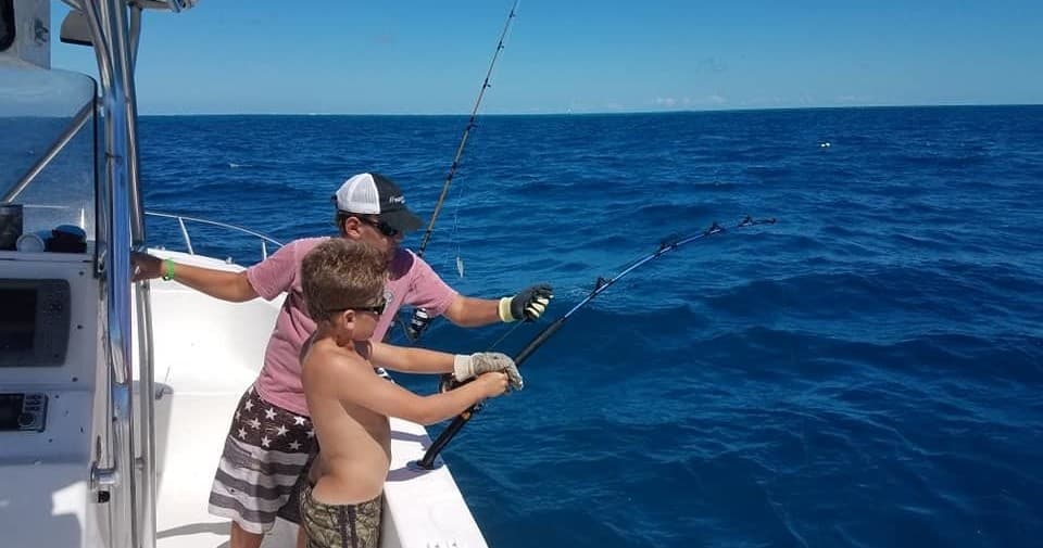 Anglers deep-sea fishing from boat on open blue ocean