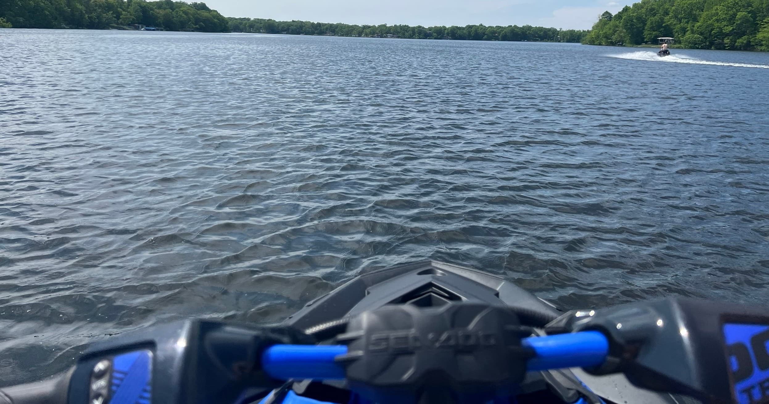 Jet ski cockpit view heading across wide lake, water ride POV