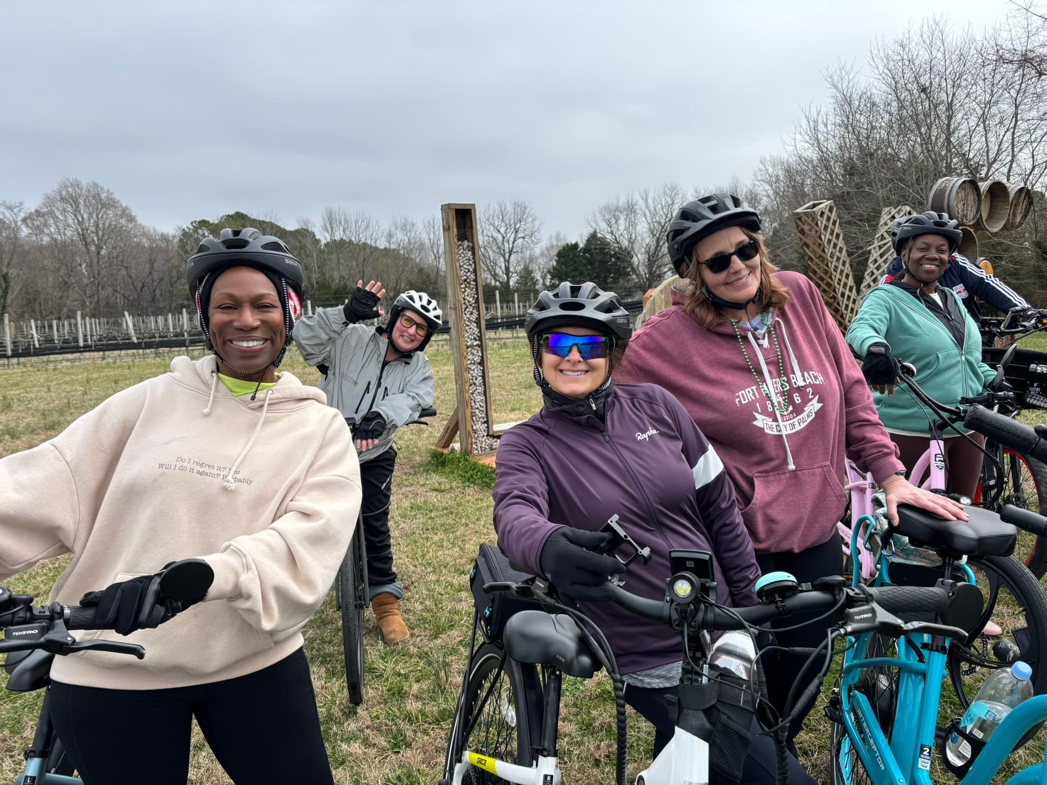 Group of e-bike riders posing in grassy field before ride