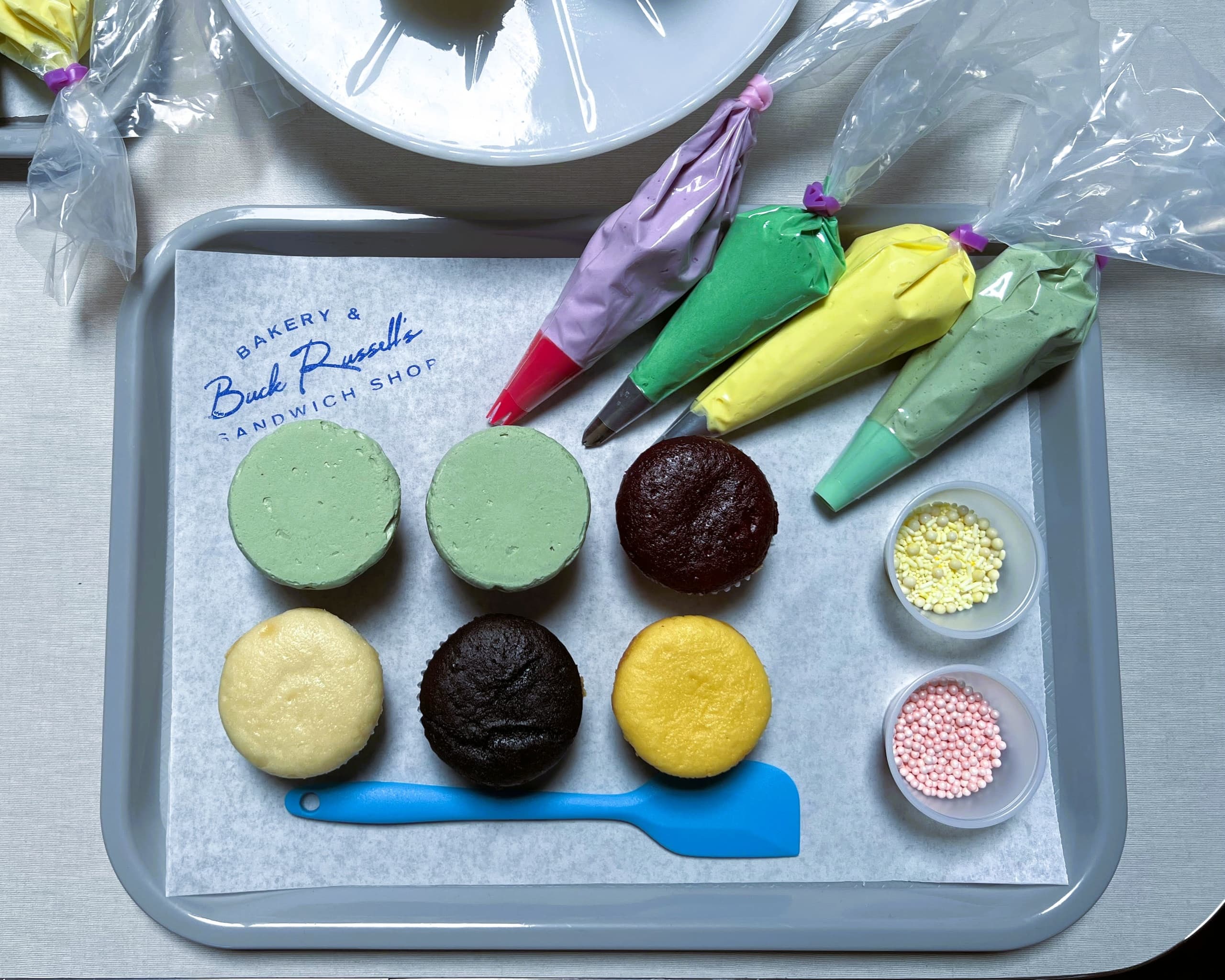 Bakery cupcake decorating tray with frosting bags and cake rounds