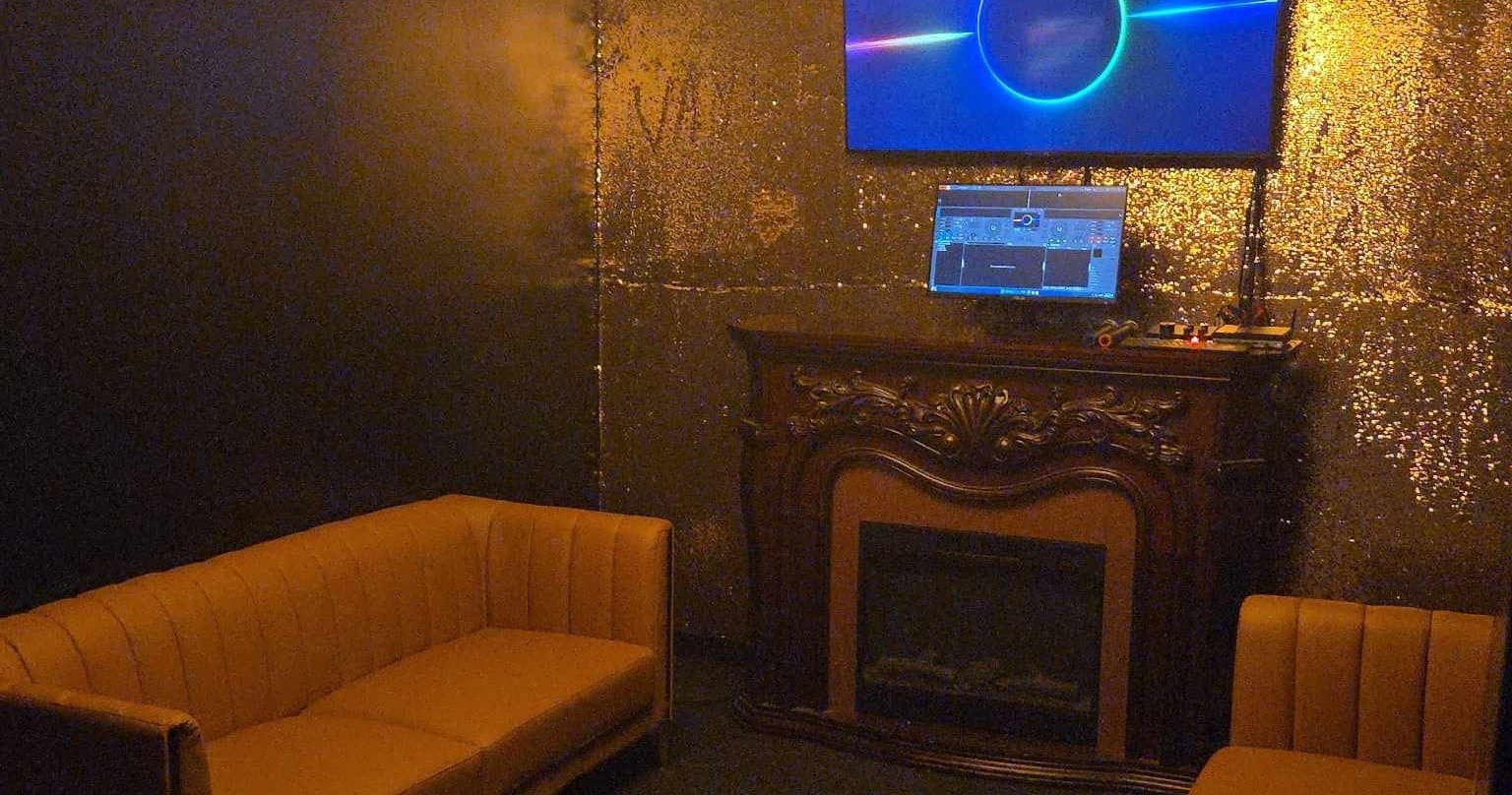 Intimate karaoke seating area with fireplace and screen lighting