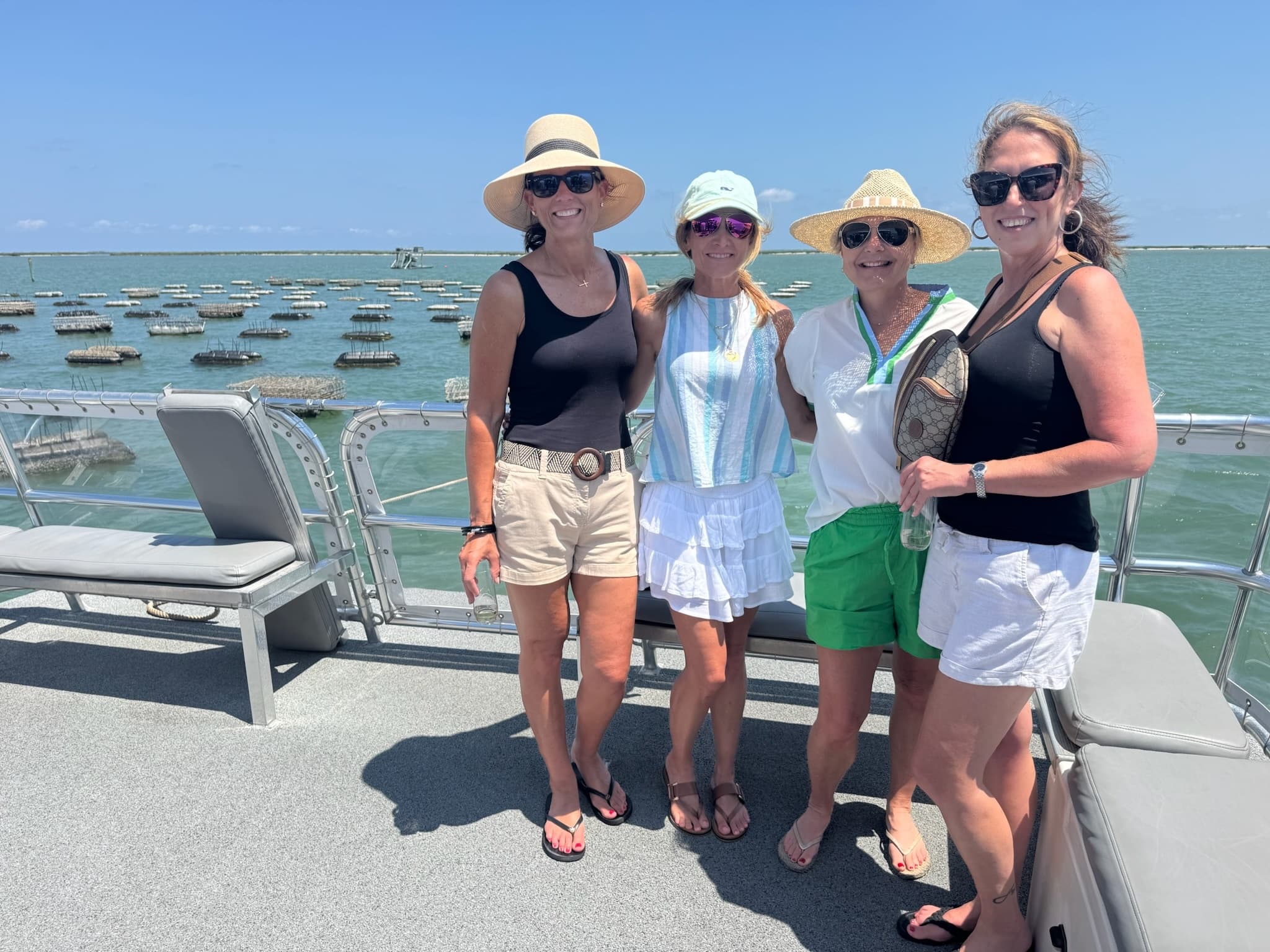 Group of passengers on deck enjoying sunny harbor dolphin cruise